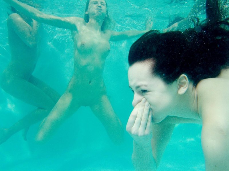The girl bathes naked underwater in