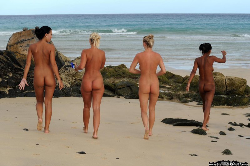 Naked girls run along the beach