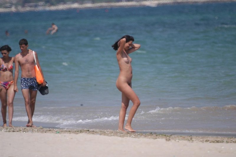 Undressed among those dressed on the beach